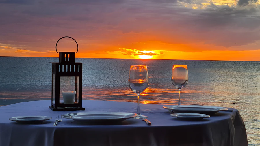 A dinner table set on the beach at sunset