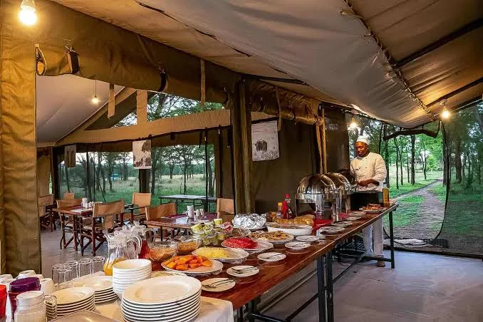 The camp chef serving a fresh buffet in the open mess tent